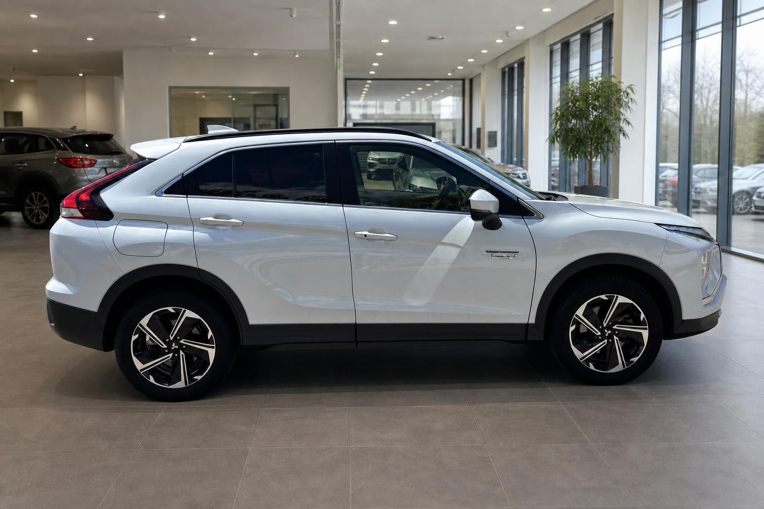 Mitsubishi Eclipse Cross PHEV in Weiß - Seitenansicht mit Leichtmetallfelgen im Autohaus Showroom
