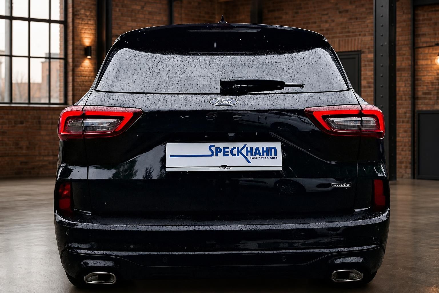 Ford Kuga Hybrid in Schwarz, Heckansicht in Showroom