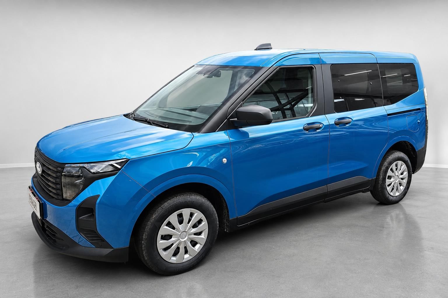 Ford Tourneo Courier in Blau, Seitenansicht schraeg vorne im Studio