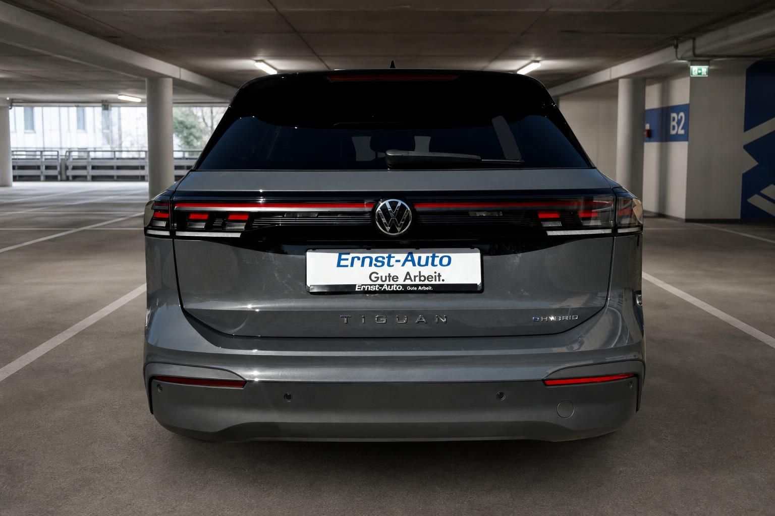 VW Tiguan Hybrid grau Heckansicht in Parkhaus – Ernst-Auto