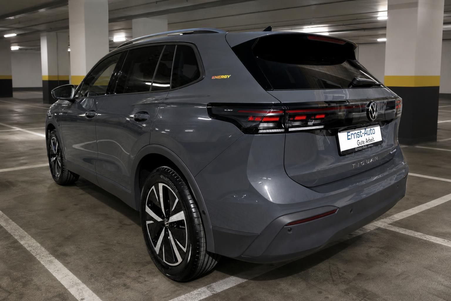 VW Tiguan eHybrid Energy grau Heck-Seitenansicht im Parkhaus