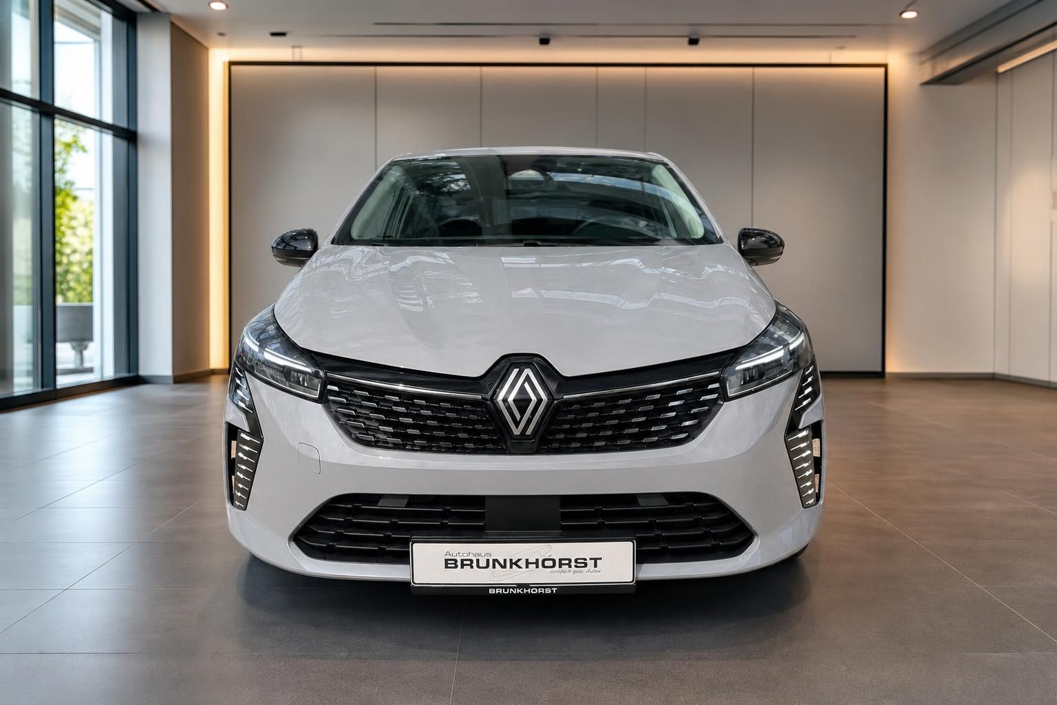 Renault Clio Frontansicht in weißer Farbe mit LED-Scheinwerfern im Autohaus Showroom