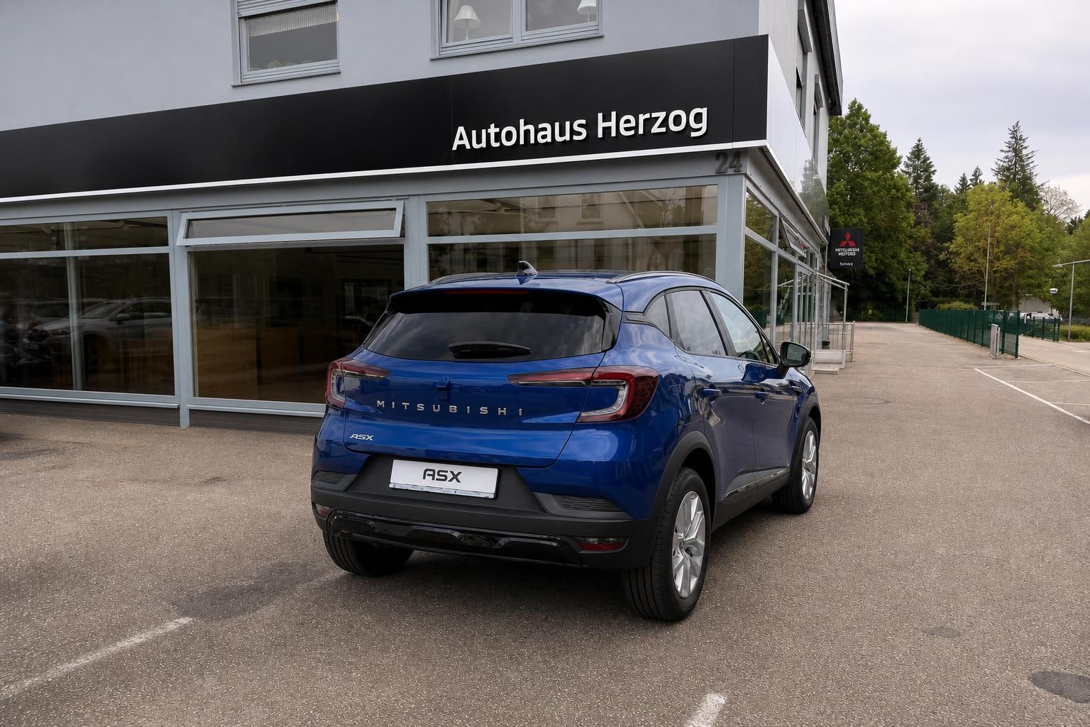 Mitsubishi ASX blau, Heckansicht vor Autohausgebaeude