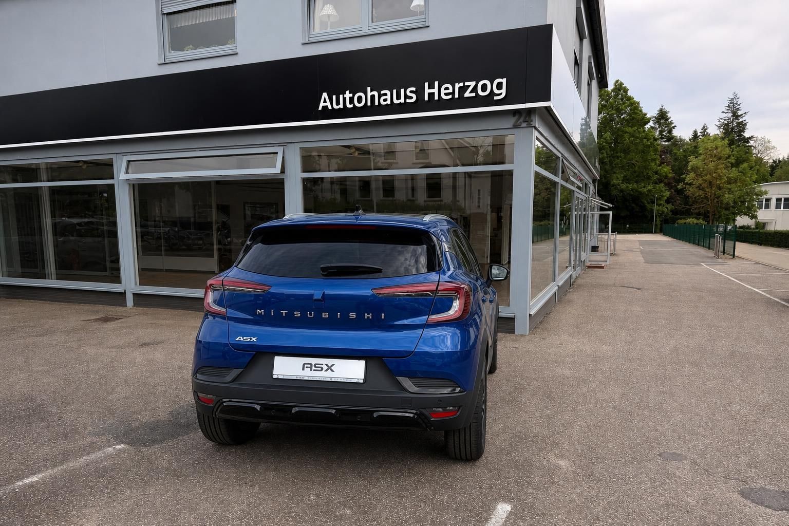 Mitsubishi ASX blau, Heckansicht vor Autohaus Herzog