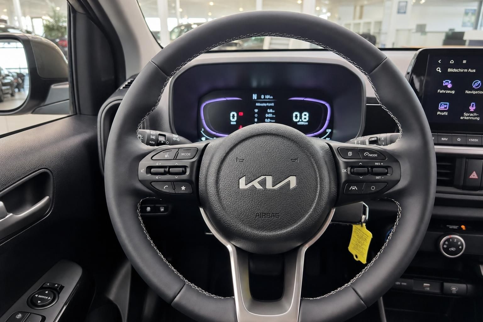 Lenkrad mit Multifunktionstasten und Kia Logo im Fahrzeuginnenraum