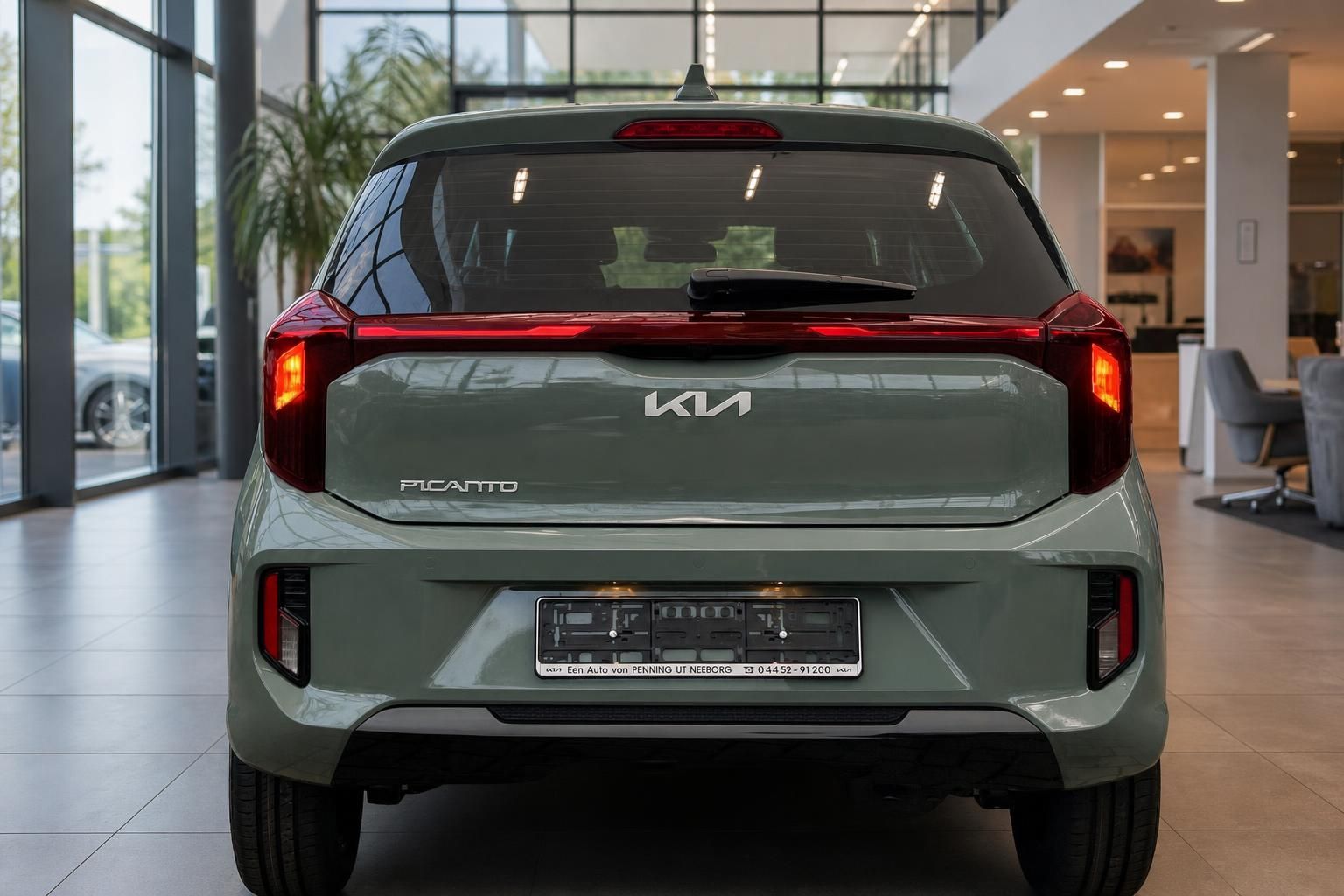 Kia Picanto in Gruen, direkte Heckansicht im Autohaus