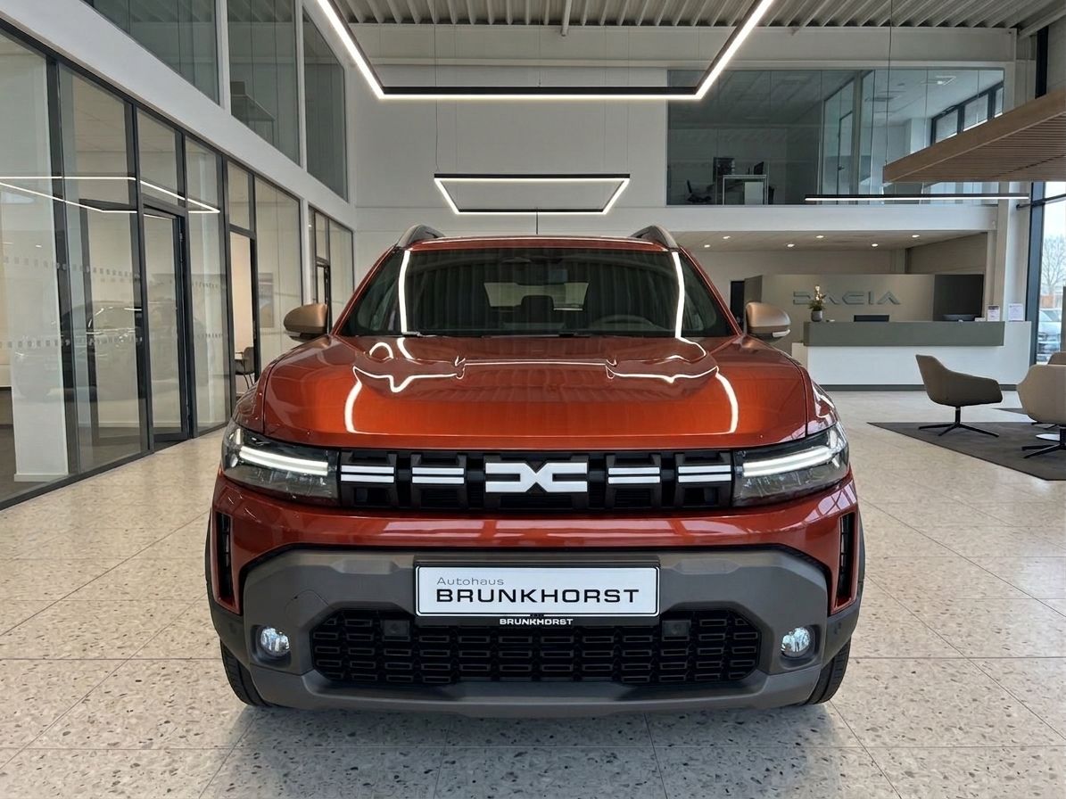 Roter Dacia SUV Frontansicht mit markanter Kühlergrille im Autohaus Showroom