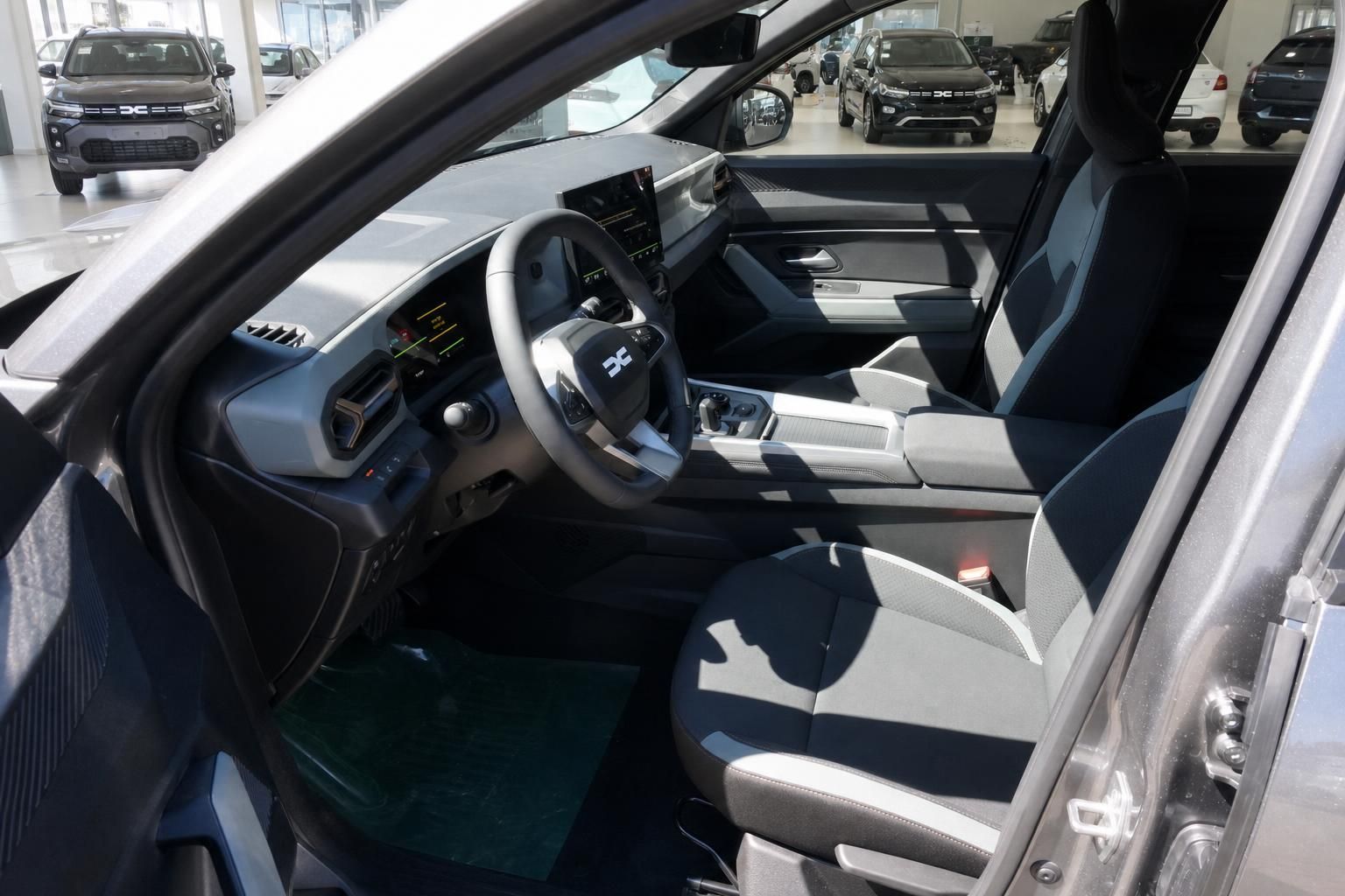 Innenraum eines modernen Fahrzeugs mit Lenkrad, Armaturenbrett und Sitzen in hellem Design