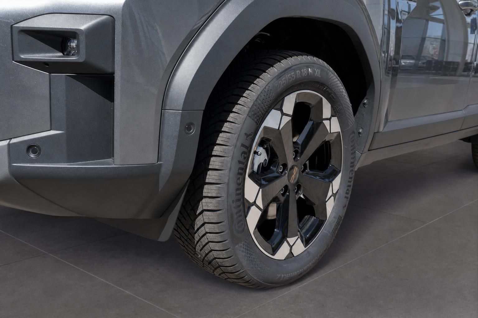 Detailaufnahme Rad und Reifen eines grauen SUVs mit Leichtmetallfelgen im Autohaus