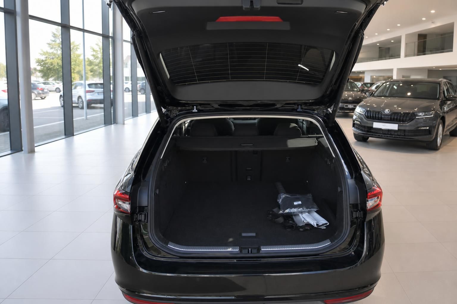 Geöffneter Kofferraum eines schwarzen Fahrzeugs mit großem Laderaum im Autohaus-Showroom
