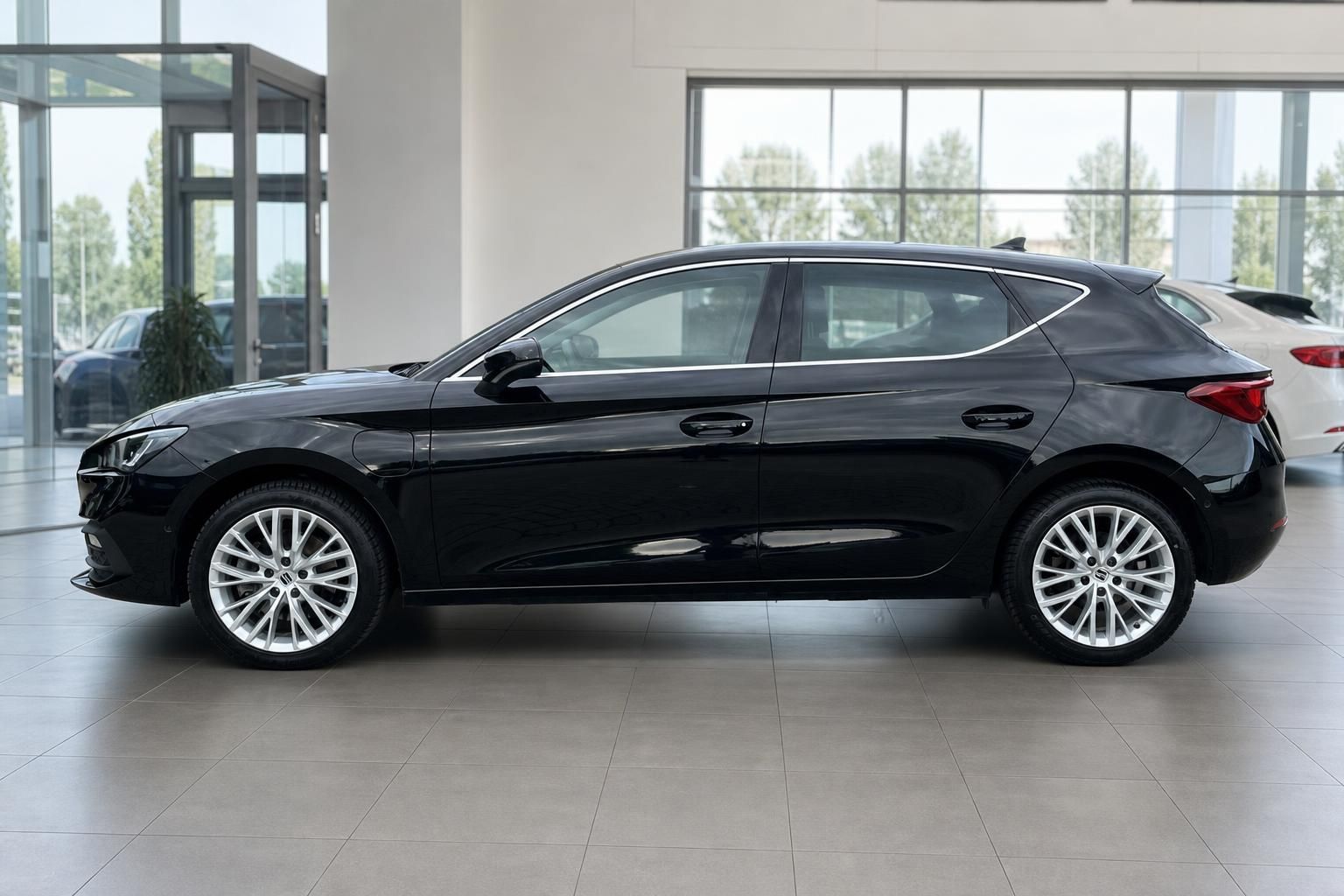 SEAT Leon schwarz Seitenansicht mit Panoramadach im Showroom