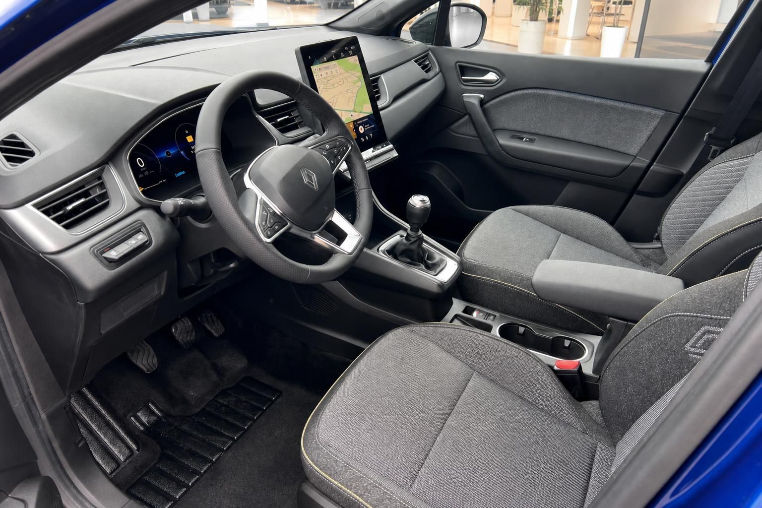 Renault Captur Innenansicht mit Fahrersitz, Lenkrad und digitalem Cockpit in grauer Ausstattung