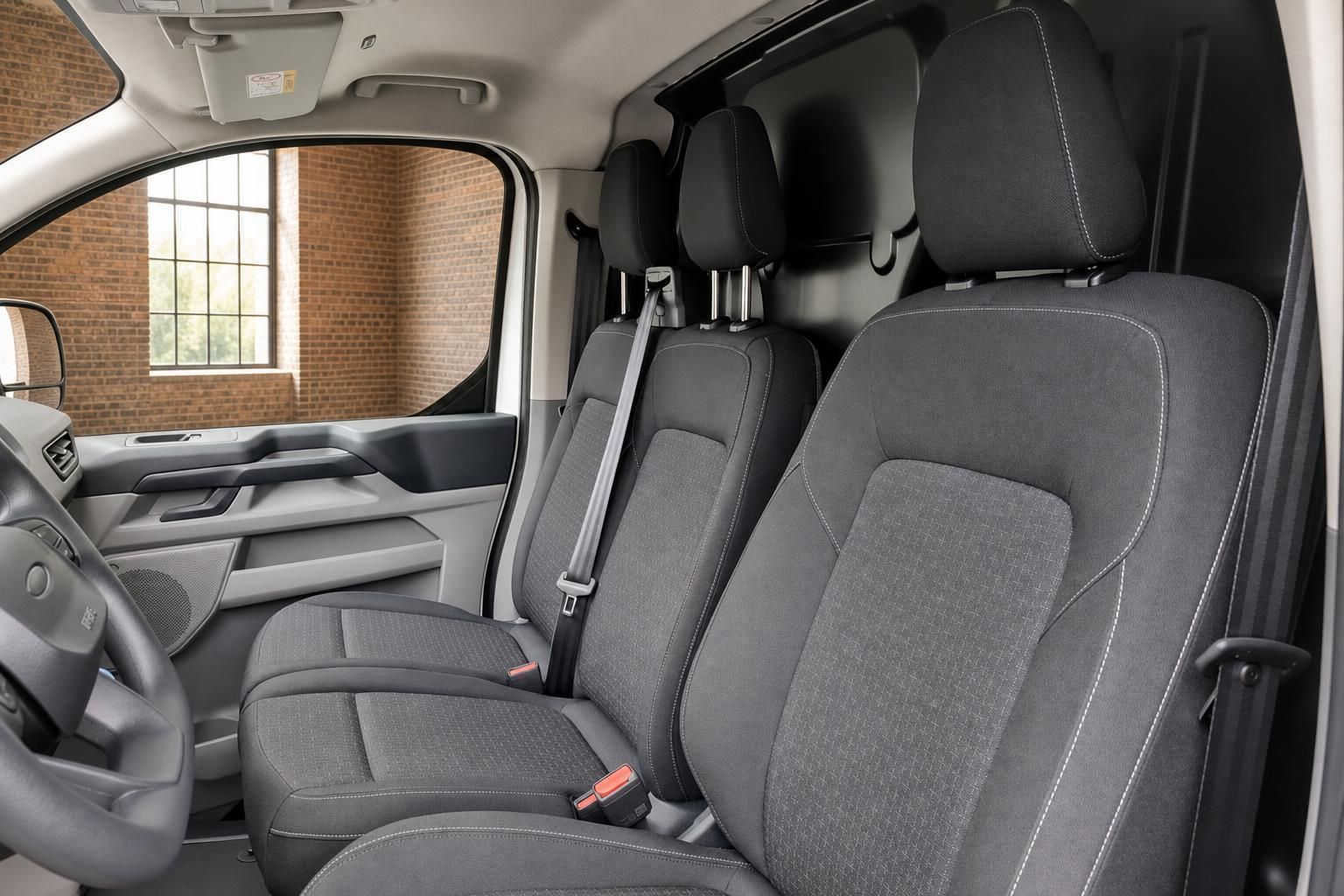Ford Transit Innenraum mit grauen Stoffsitzen und Sicherheitsgurten