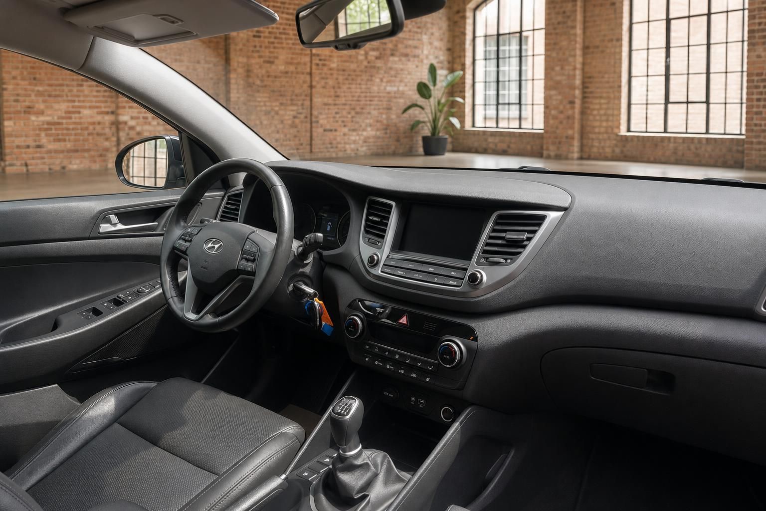 Hyundai Tucson Cockpit – Armaturenbrett, Infotainment-Display und Schaltknauf in grauem Interieur