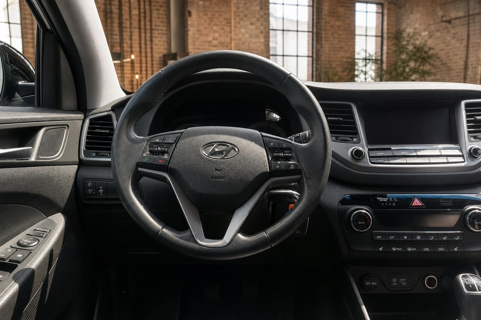 Hyundai Tucson Lenkrad-Nahaufnahme – Multifunktionstasten, Klimaanlage und Infotainment im Hintergrund