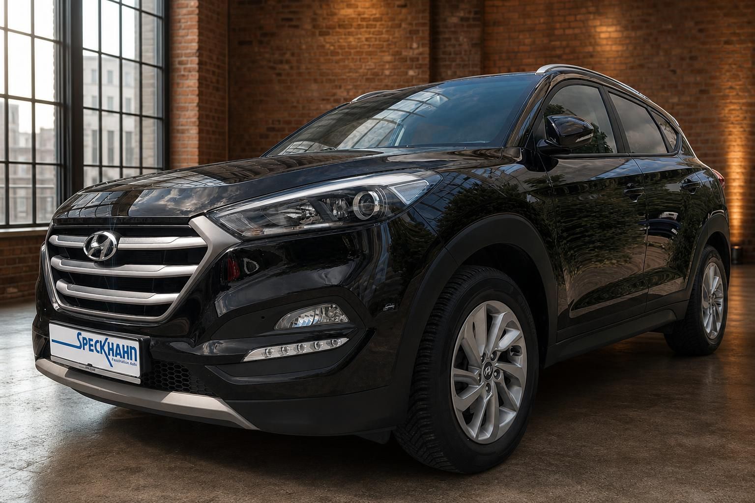 Hyundai Tucson schwarz Frontansicht schräg links im Showroom – gepflegter SUV Gebrauchtwagen