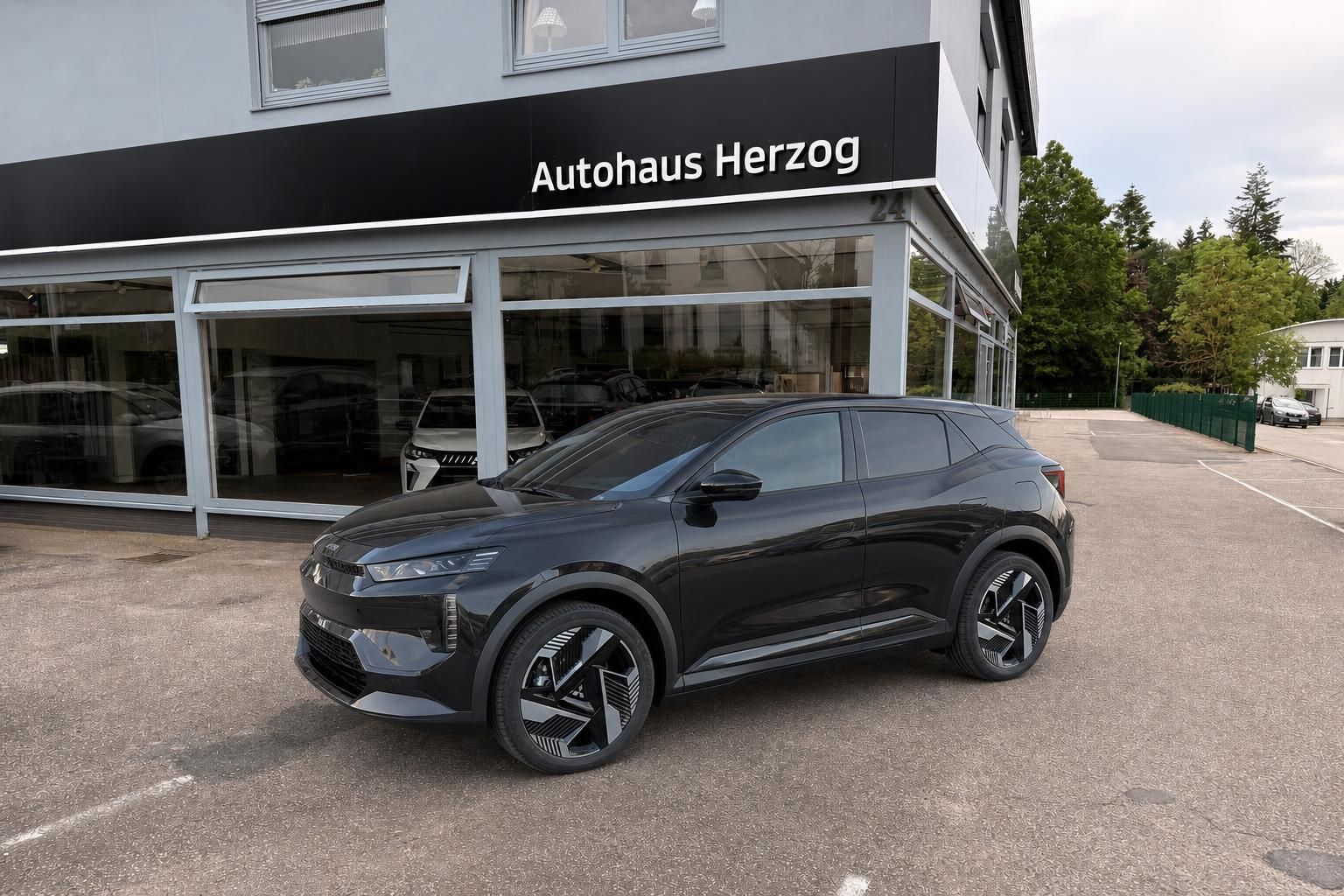 Schwarzer SUV vor Autohaus Herzog - Seitenansicht des modernen Elektrofahrzeugs
