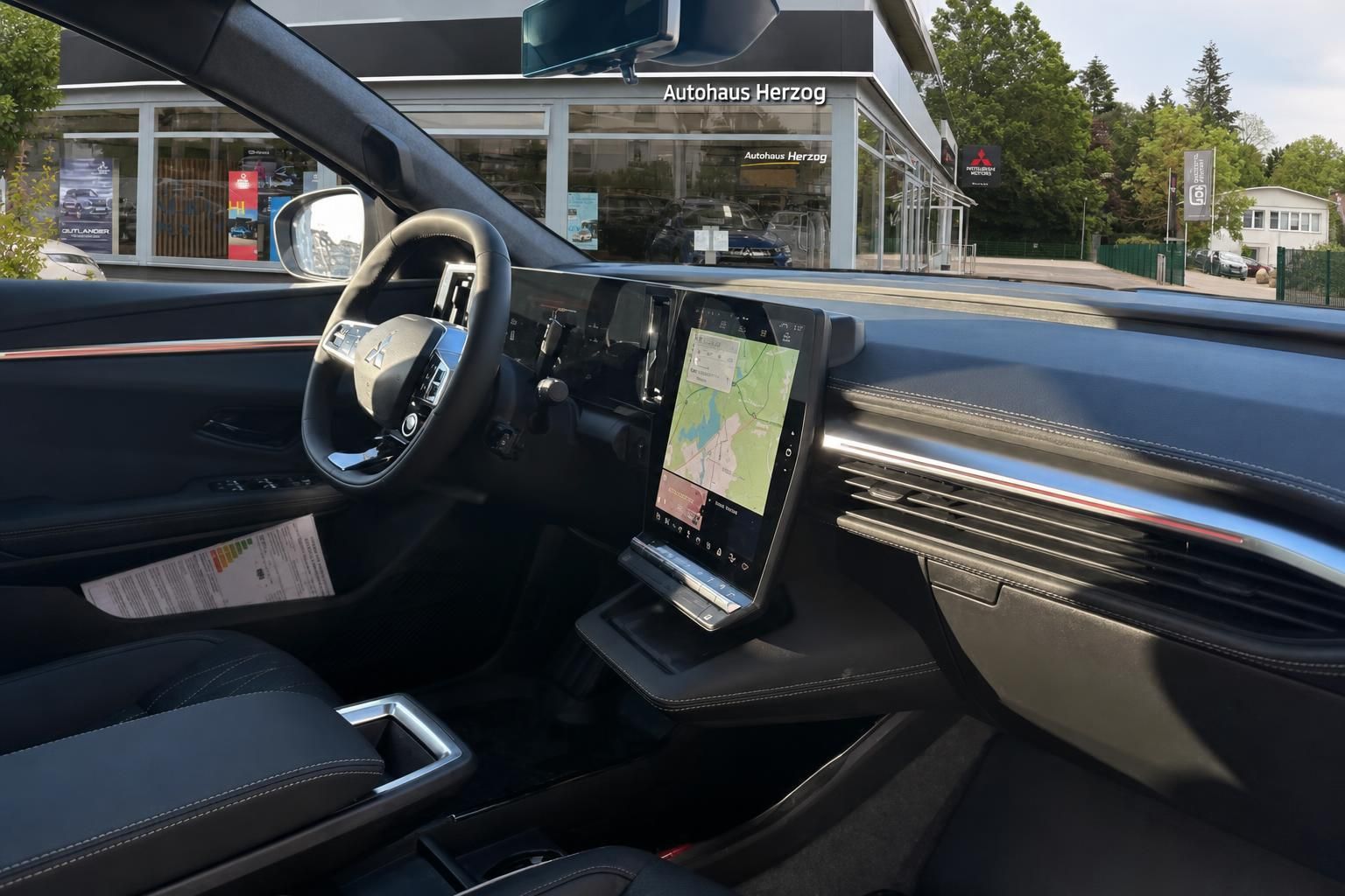Eleganter Fahrzeuginnenraum mit Lenkrad, Touchscreen und modernem Cockpit-Design