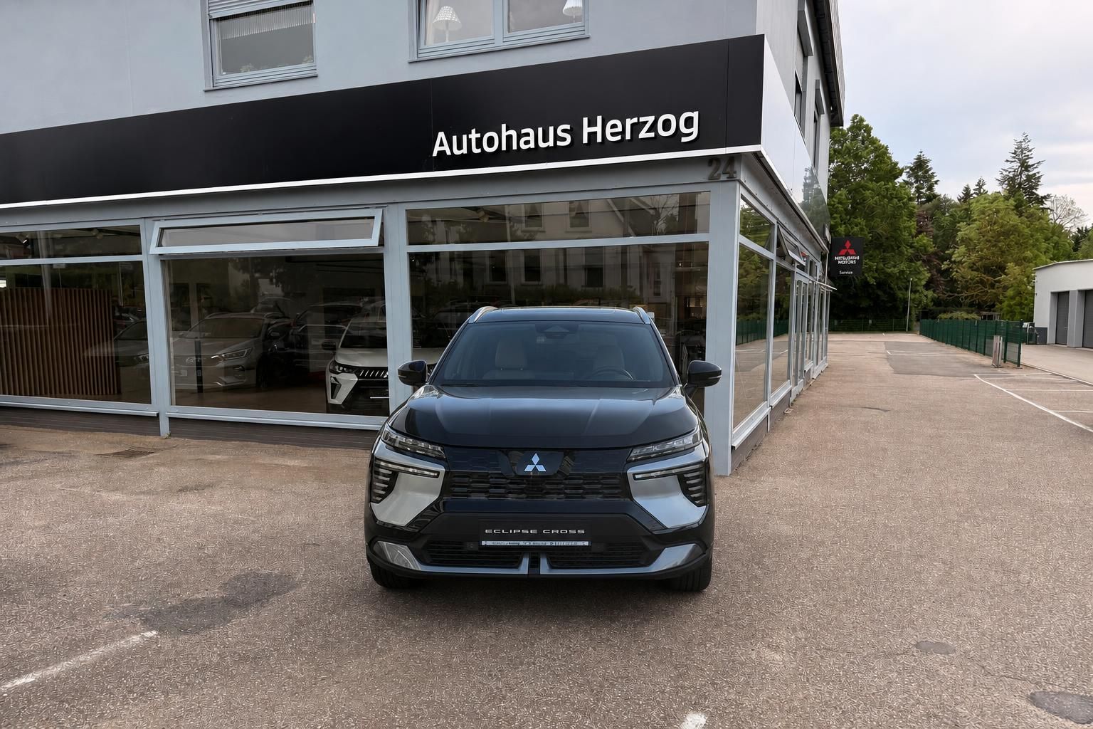 Mitsubishi Eclipse Cross Frontansicht schwarz - moderner SUV vor Autohaus Herzog Showroom