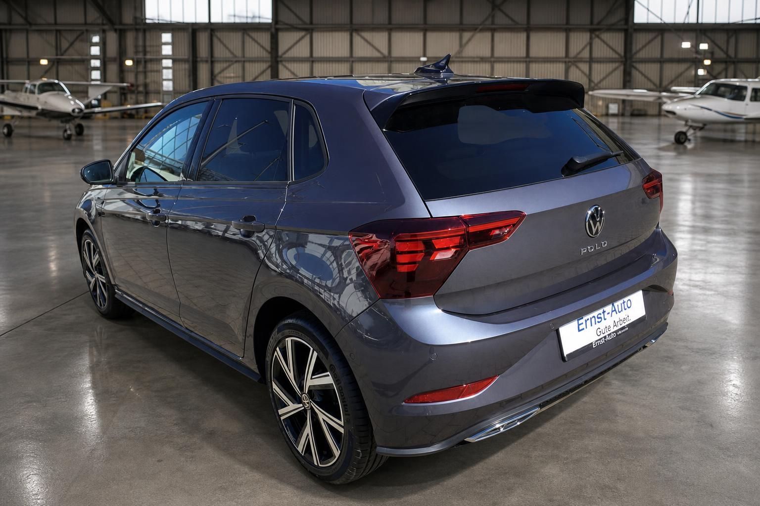 Volkswagen Polo grau metallic Heckansicht mit Spoiler und Alufelgen im Hangar