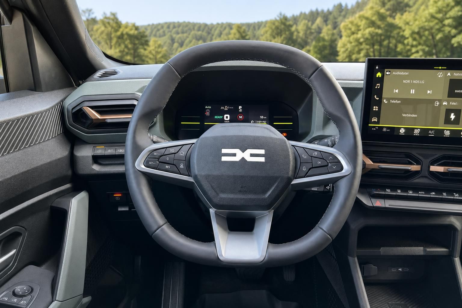 Fahrzeug Cockpit mit Lenkrad, digitalem Kombiinstrument und Infotainment-Display vor Berglandschaft