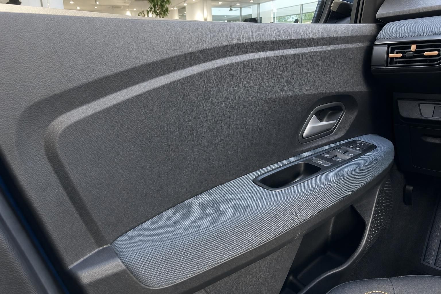 Moderne Fahrzeugtür-Verkleidung mit elektrischen Fensterhebern und Türgriff aus grauem Textil