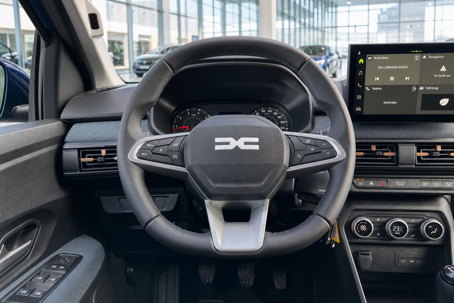 Cockpit-Ansicht mit Lenkrad, Armaturenbrett und Infotainment-System in modernem Fahrzeug