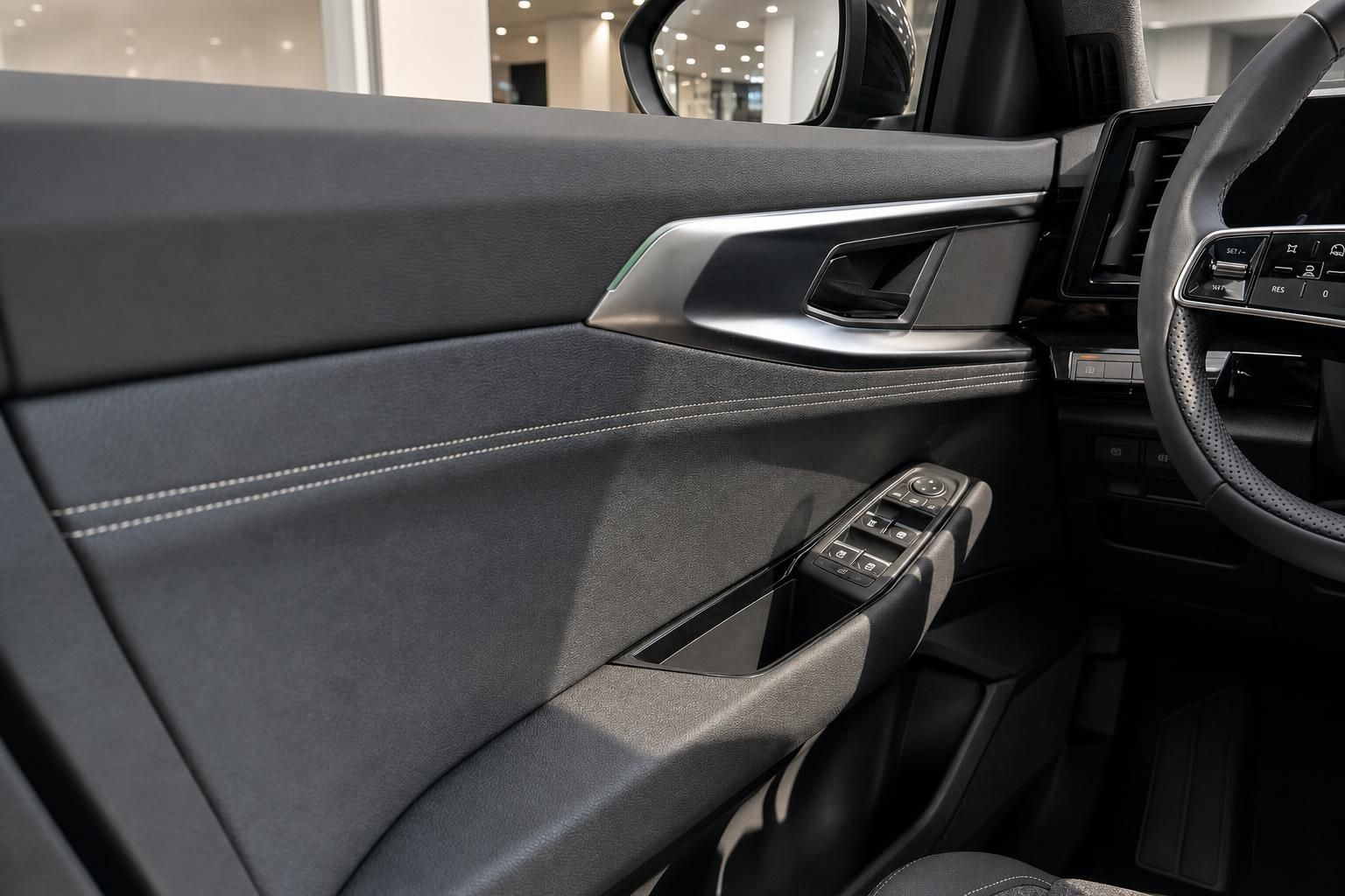 Detailansicht Tuerverkleidung mit Bedienelementen und Fensterheberschalter im Fahrzeug