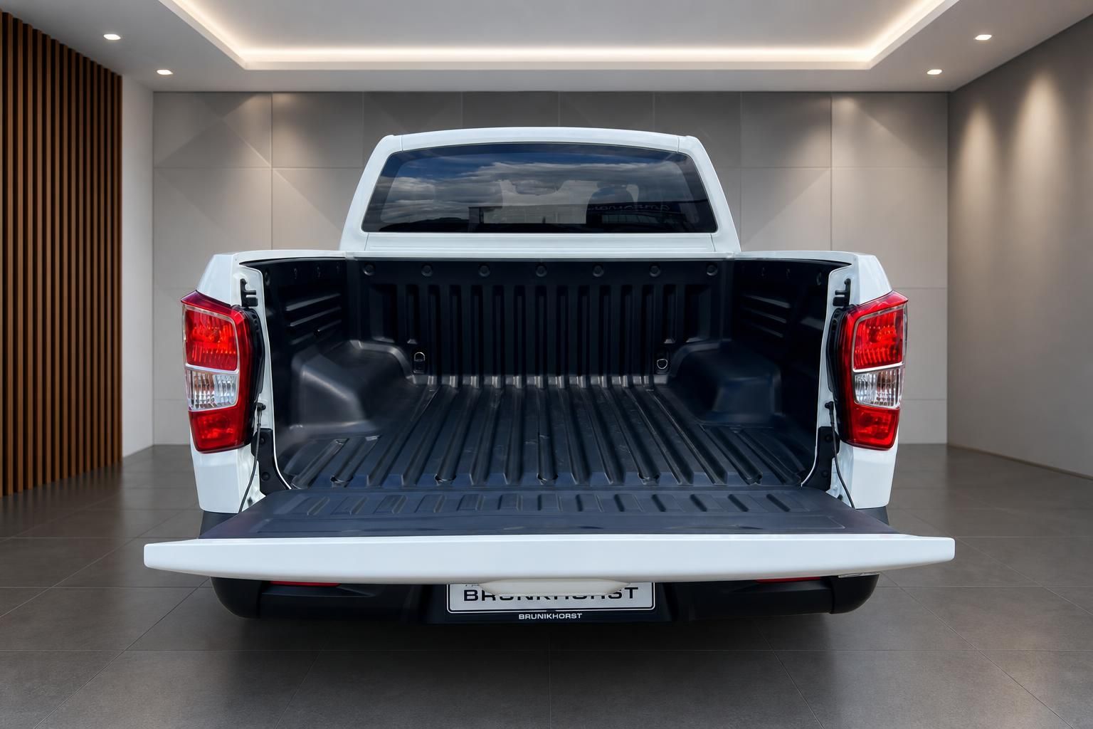 Weißer Pickup-Truck Ladeflächenansicht von hinten mit geöffneter Heckklappe im modernen Showroom