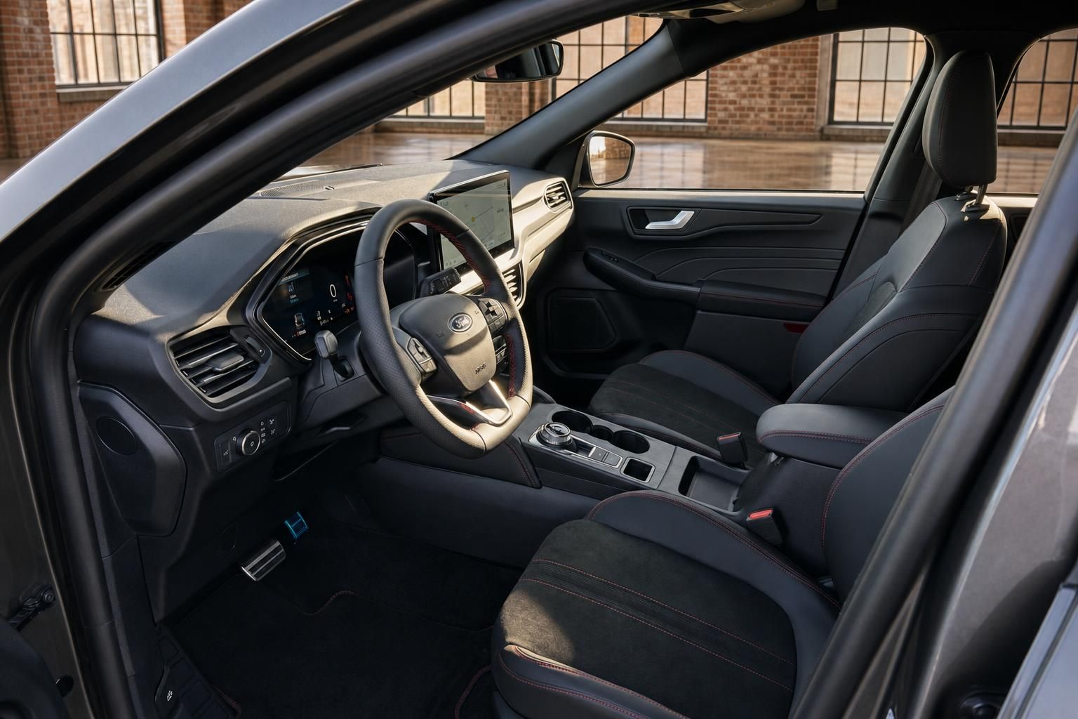 Ford Kuga Innenraum Fahrerseite mit Lenkrad, Touchscreen und schwarzen Sportsitzen mit roter Naht