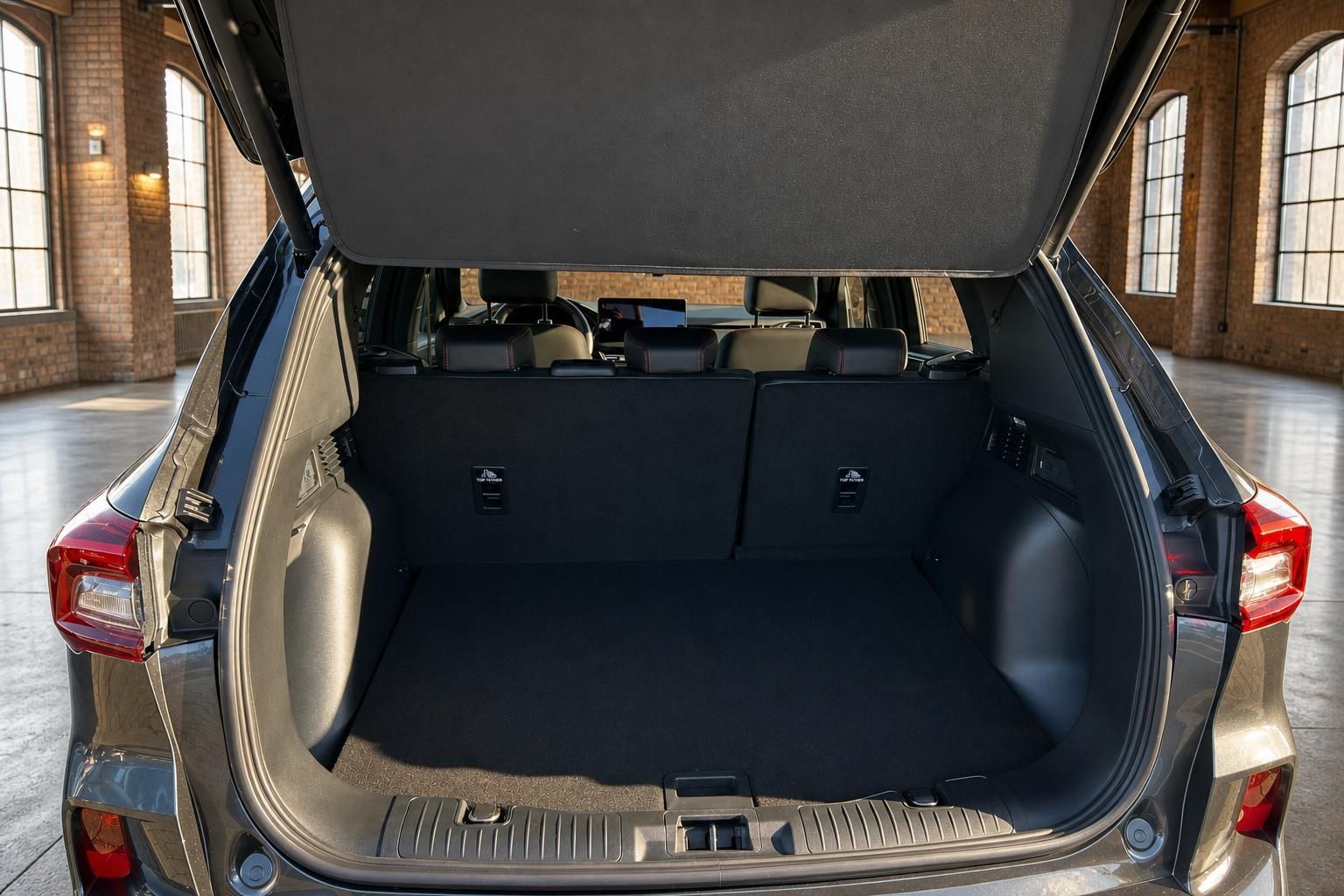 Ford Kuga SUV grau – geöffneter Kofferraum mit großem Ladevolumen in Industriehalle
