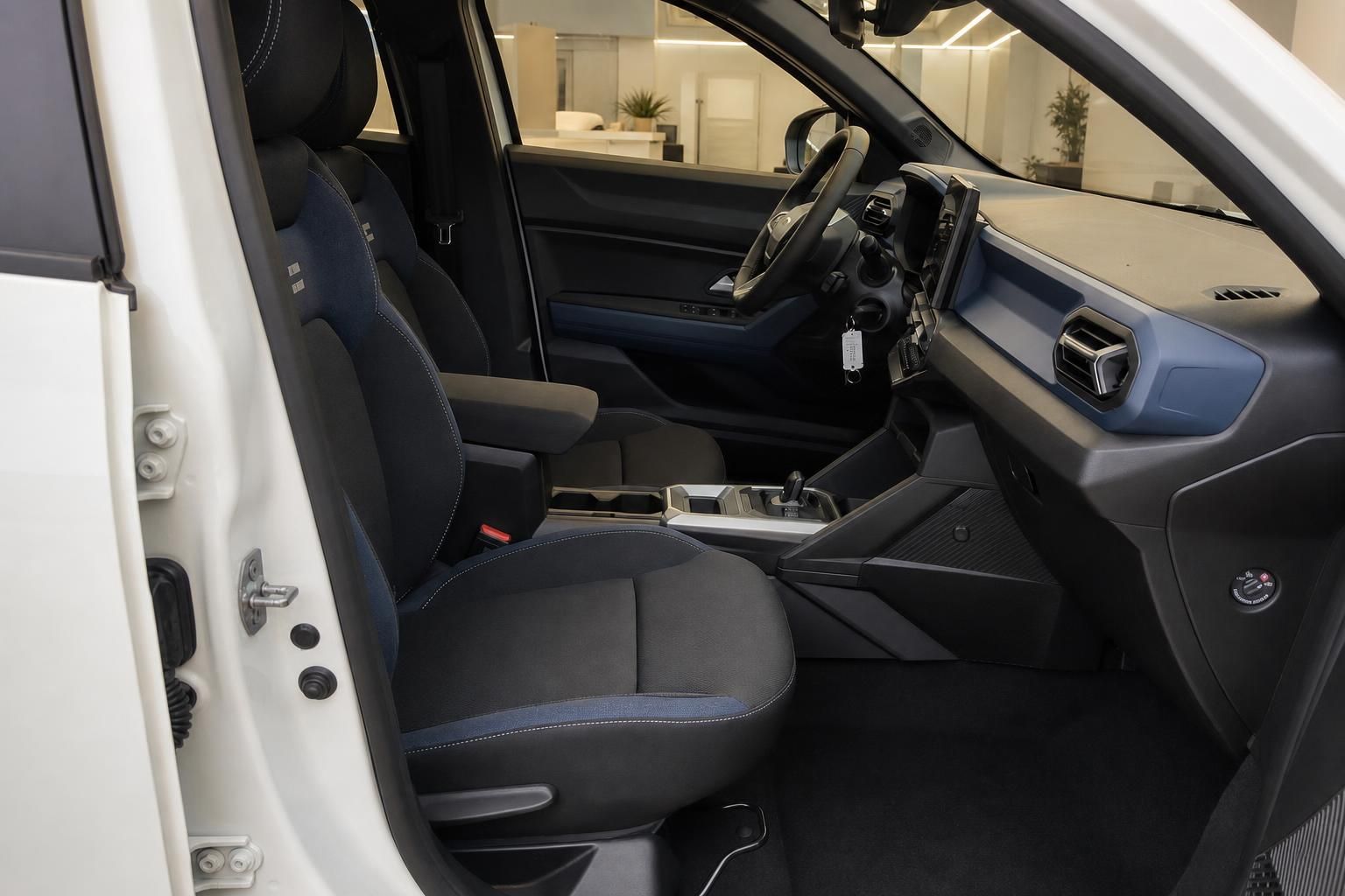 Dacia SUV Innenraum Vordersitze schwarz-blau mit Mittelkonsole und Armaturenbrett