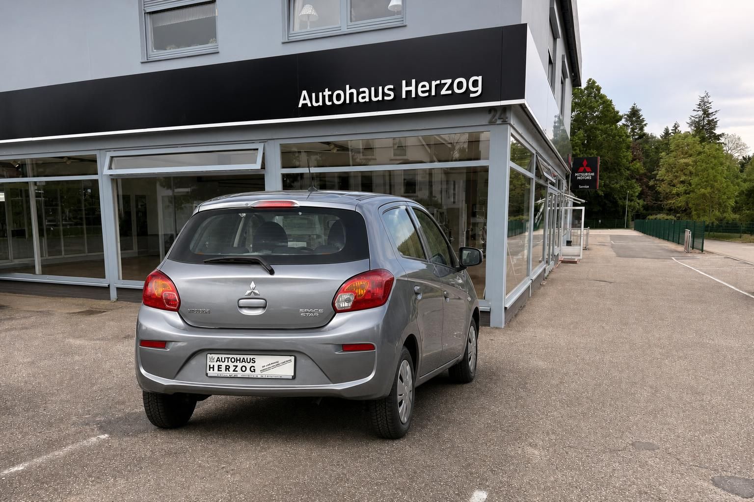 Mitsubishi Space Star in silber, Heckansicht vor Autohaus Herzog