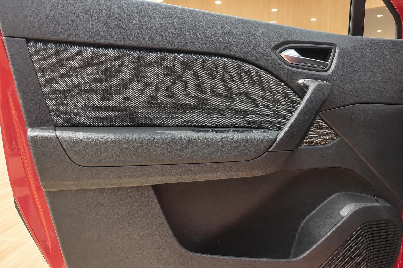 Detailansicht der Türverkleidung eines roten Renault mit Stoffeinsatz