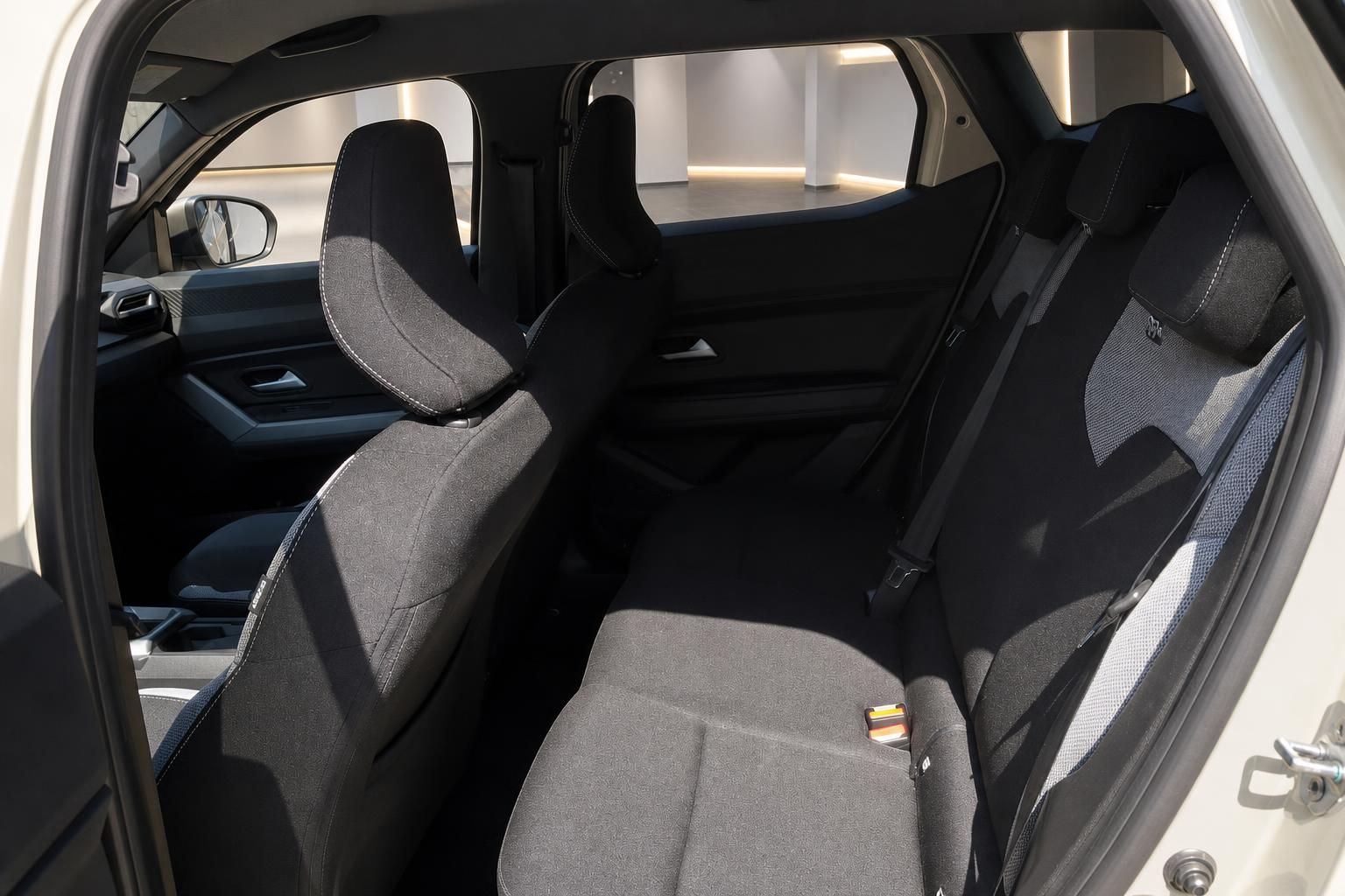 Dacia SUV Rücksitzbank schwarz-grau mit Blick durch geöffnete Seitentür