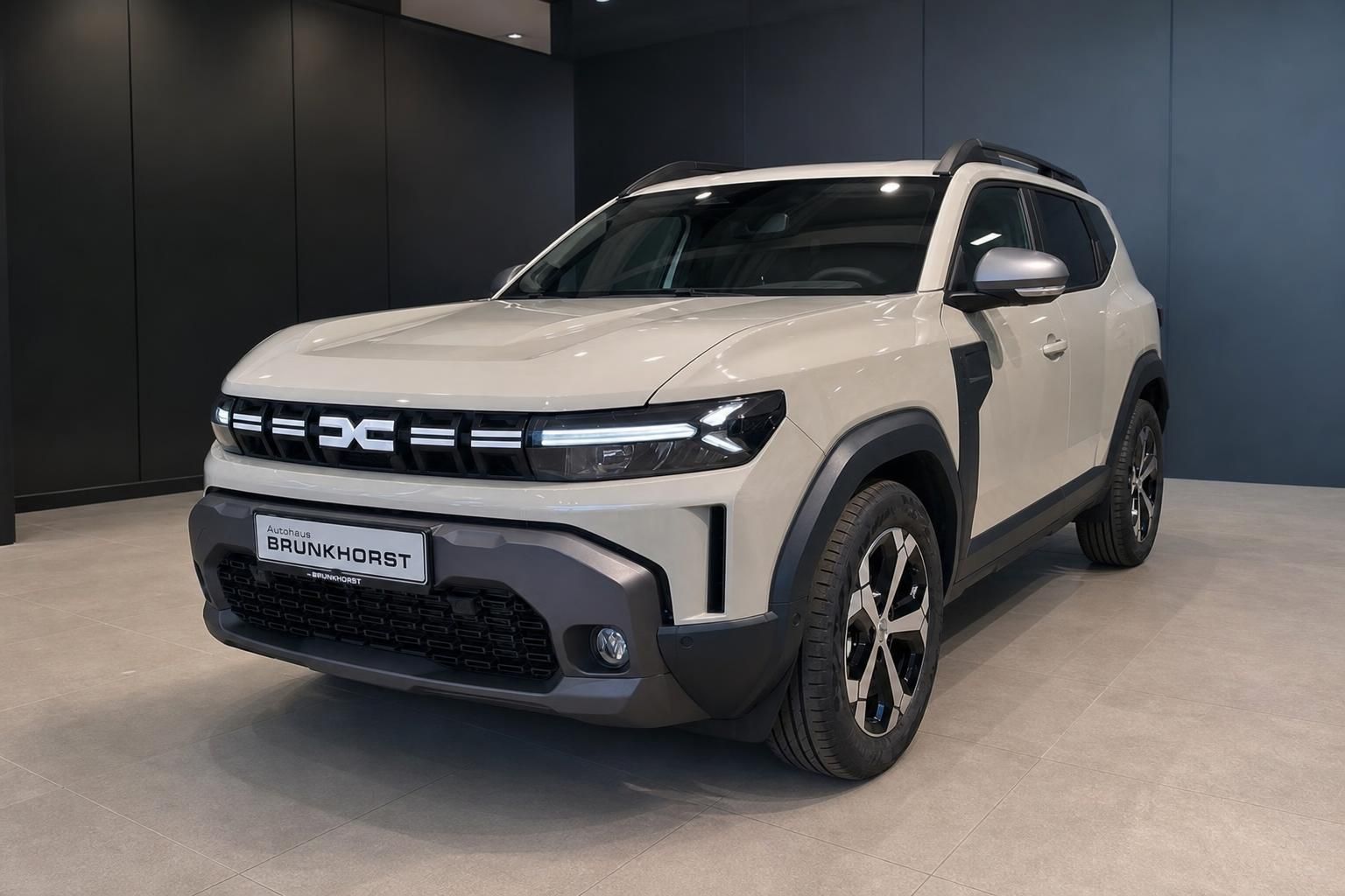 Dacia Duster Hybrid SUV in Beige Schrägheckansicht vorne links im Autohaus