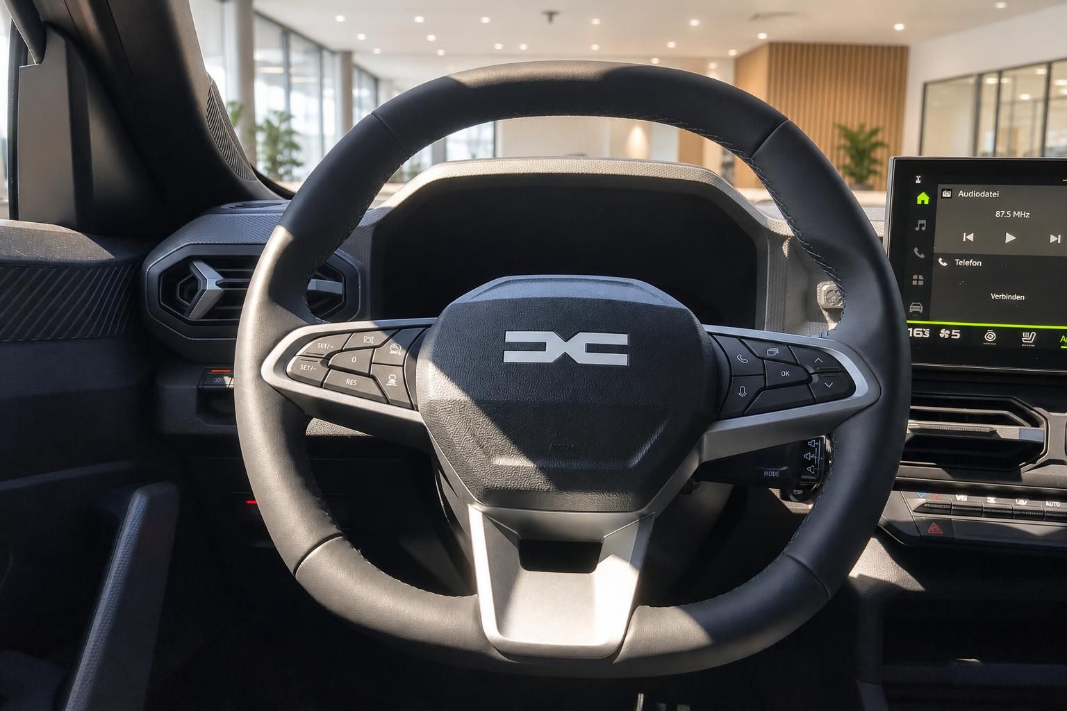 Dacia Lenkrad mit Logo und Infotainment-Display im Innenraum