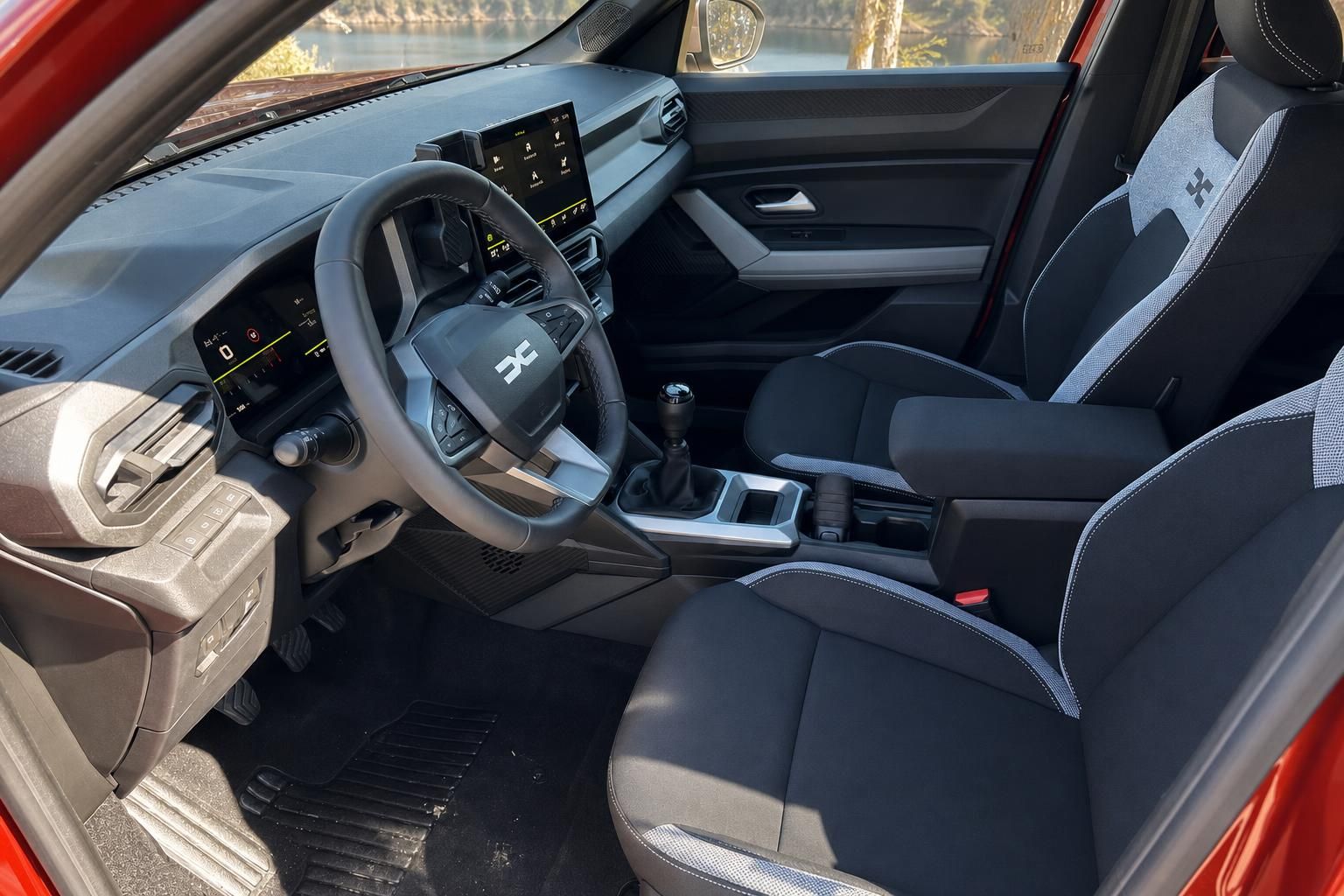 Dacia Innenraum mit Lenkrad, Touchscreen und sportlichen Sitzen - moderne Ausstattung in Grau