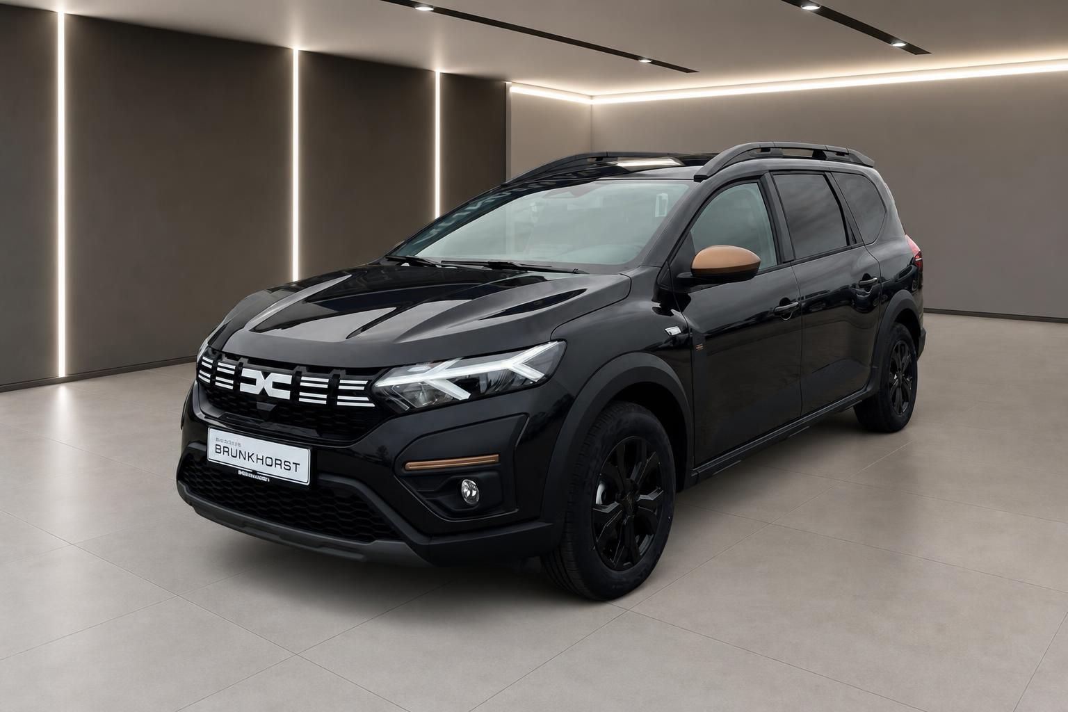 Dacia SUV Seitenansicht in schwarz mit Dachreling und schwarzen Felgen im Autohaus