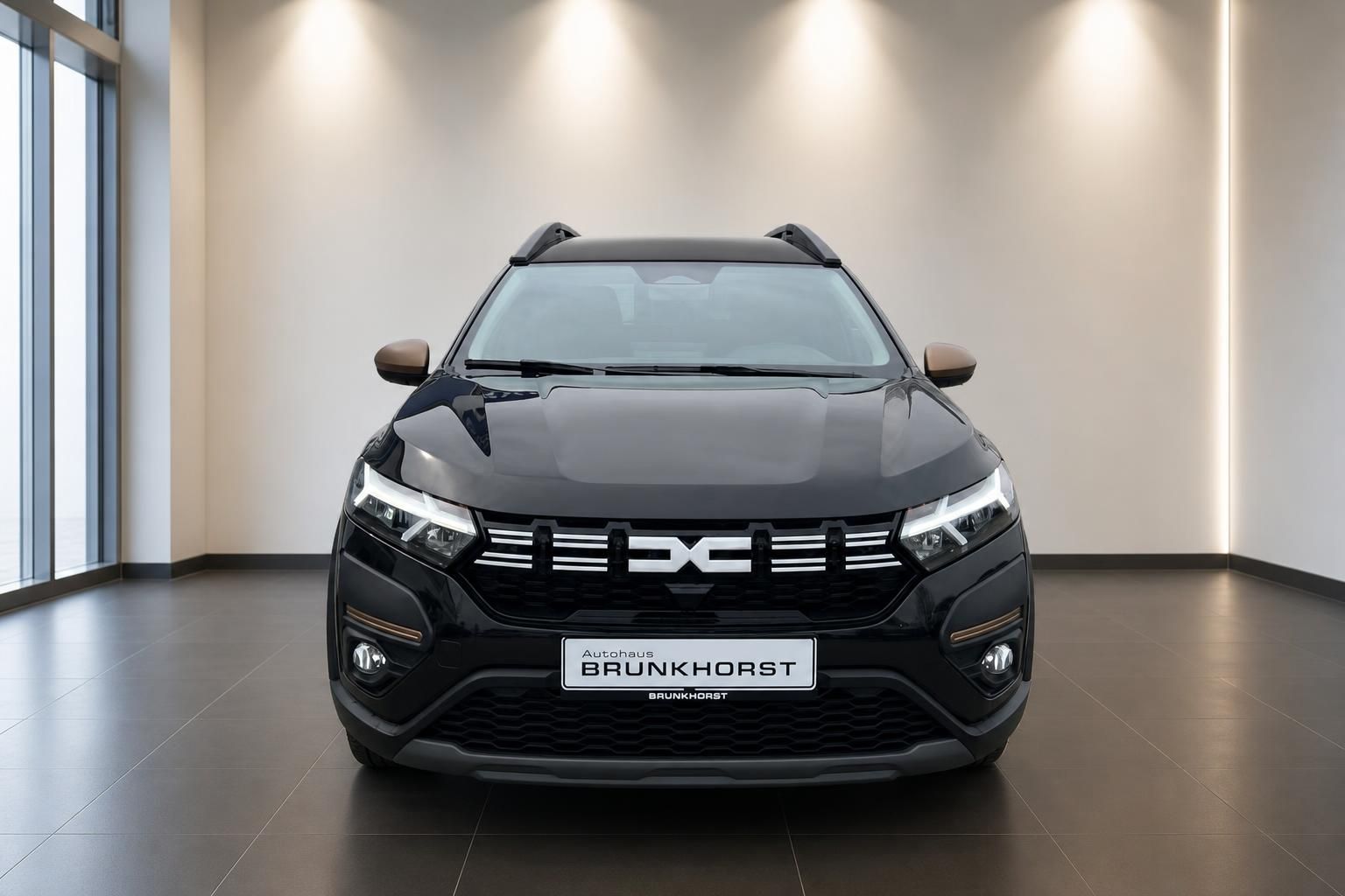 Dacia SUV Frontansicht in grau mit LED-Scheinwerfern im modernen Autohaus Showroom
