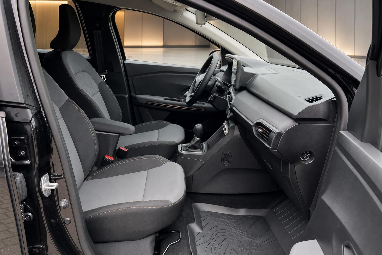 Fahrzeuginnenraum mit grauen Sitzen, Schaltgetriebe und modernem Dashboard