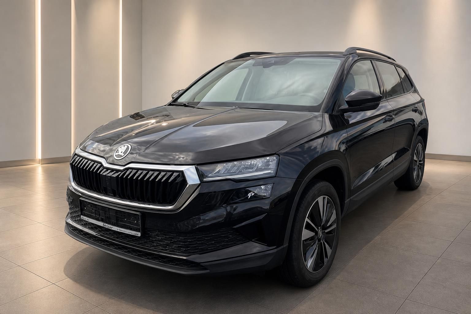 Skoda Karoq schwarz Frontansicht im Showroom – kompakter SUV mit Chromgrill und Leichtmetallfelgen
