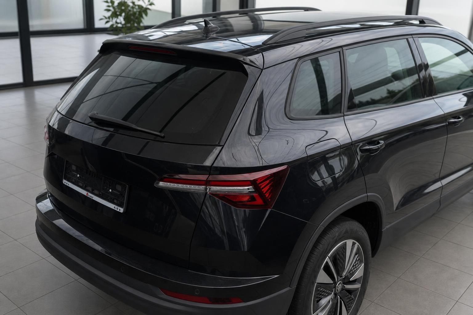Skoda Karoq schwarz Heckansicht schräg – SUV mit LED-Rückleuchten und Dachreeling im Autohaus