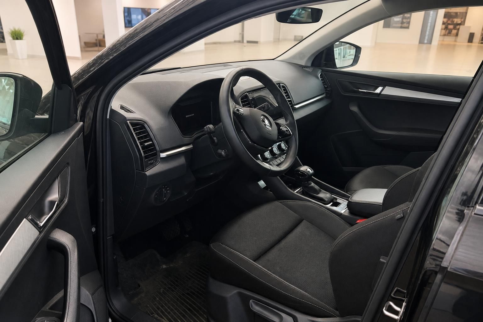 Skoda Karoq Innenraum – schwarze Stoffsitze, Lenkrad mit Škoda-Logo, Mittelkonsole und Cockpit