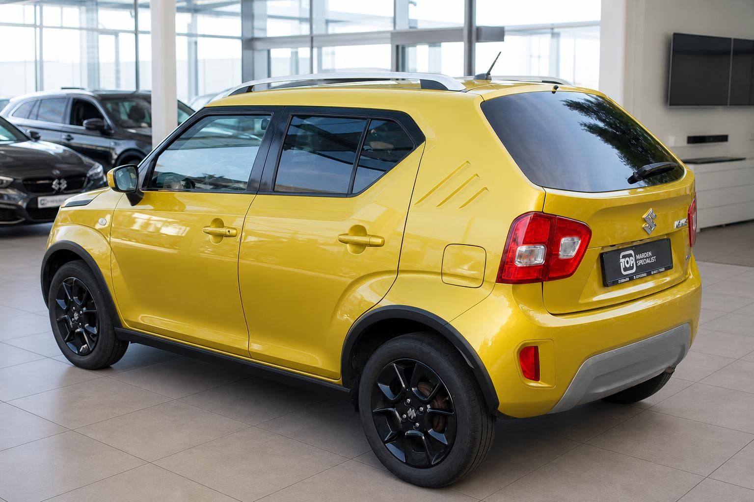 Suzuki Ignis gelb, Heckansicht seitlich im Autohaus Showroom