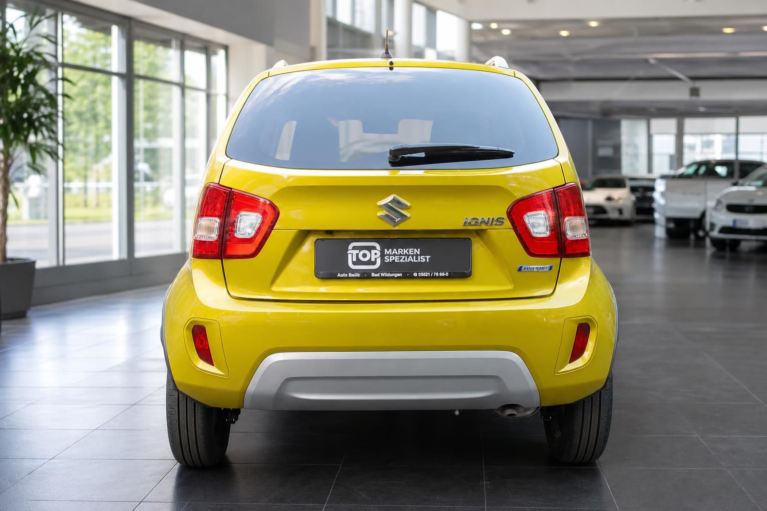 Suzuki Ignis Hybrid gelb, Heckansicht im Autohaus Showroom