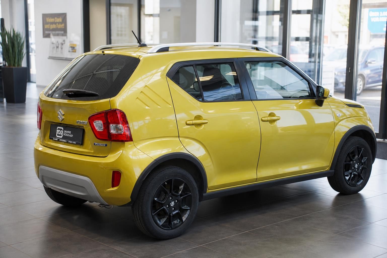 Suzuki Ignis gelb Heckansicht seitlich im Autohaus