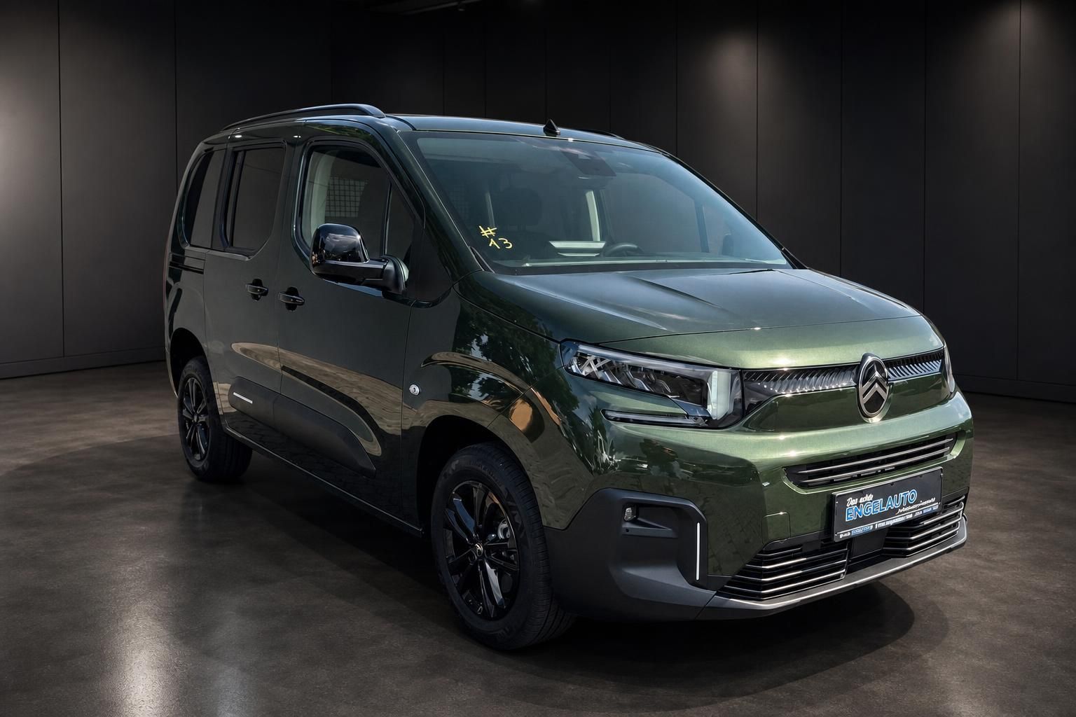 Citroen Berlingo gruen metallic, Seitenansicht schraeg vorne im Studio