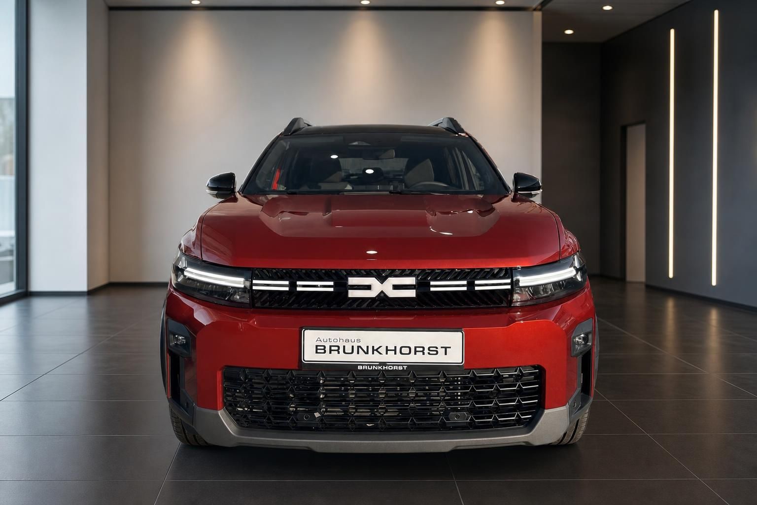 Roter Dacia SUV in modernem Autohaus-Showroom - Frontansicht mit schwarzem Dach