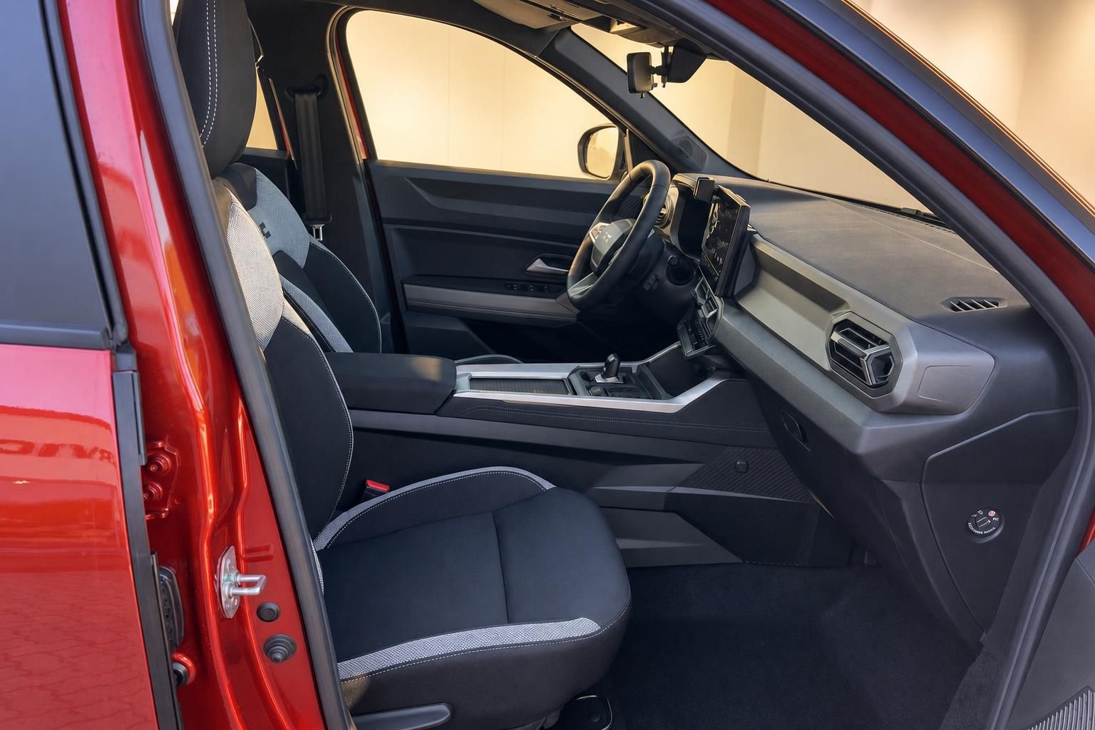 Innenraum eines roten Fahrzeugs mit schwarzen Ledersitzen und modernem Armaturenbrett